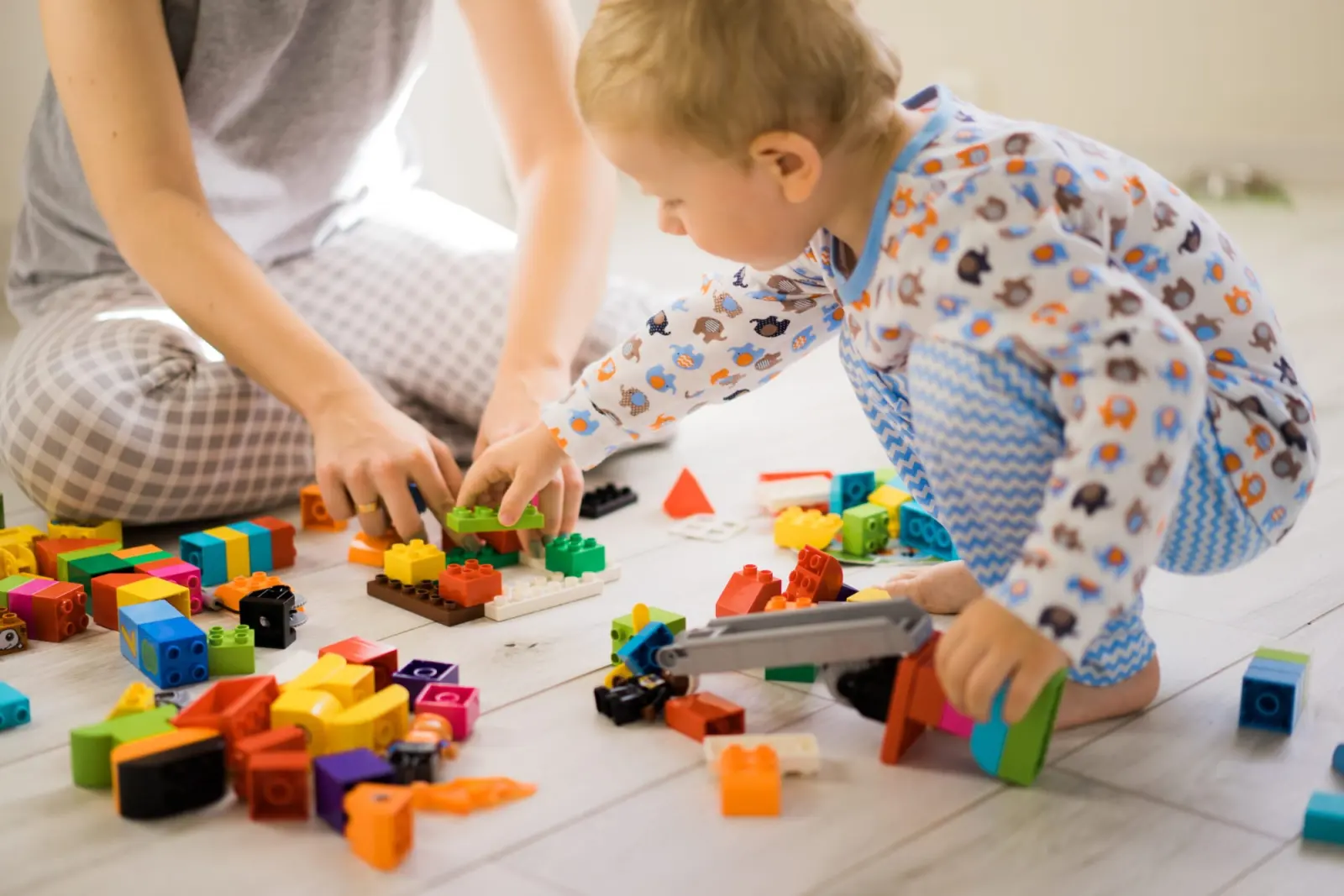 Adulte et enfant qui assemblent des briques de construction