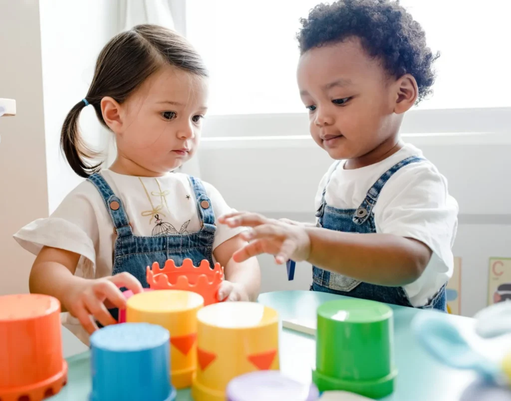 Deux tout-petits qui jouent ensemble avec des gobelets à empiler