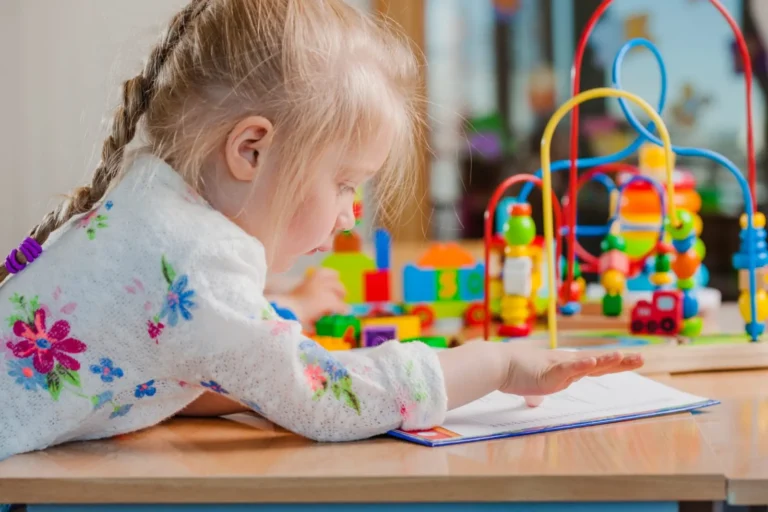 Petite fille concentrée devant un jeu d’éveil